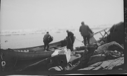 Image of Three men loading long boat